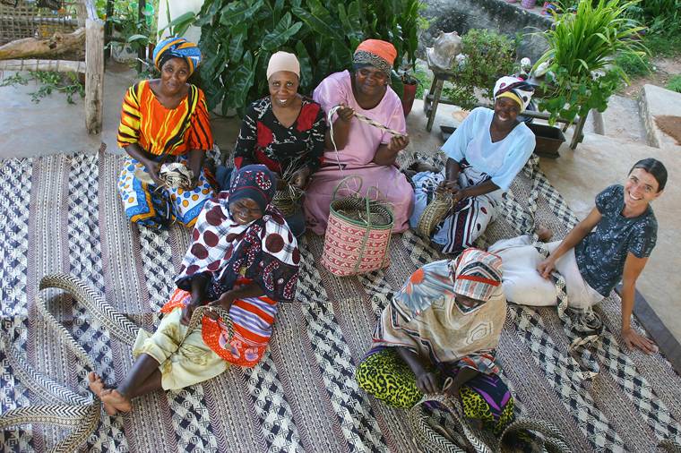 The women's cooperative weaving together on a finished mat