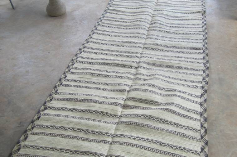 A long woven hall runner mat laid out on a terrace